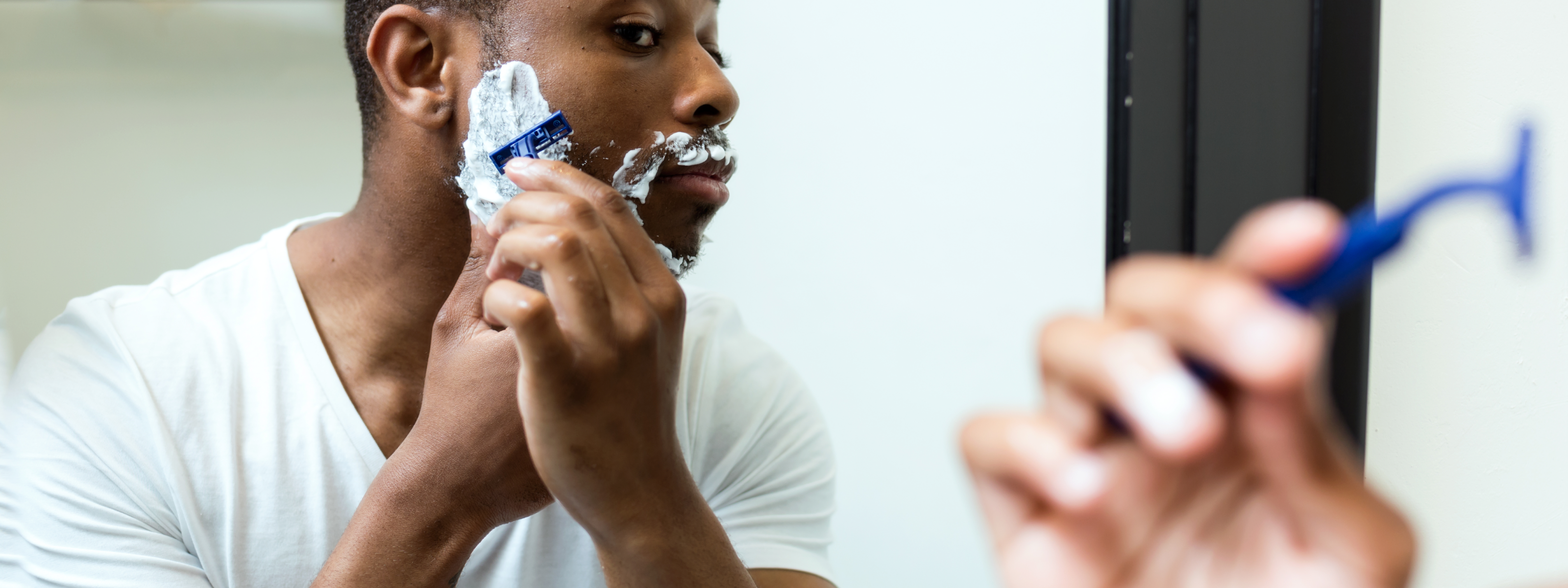 Man shaving in mirror